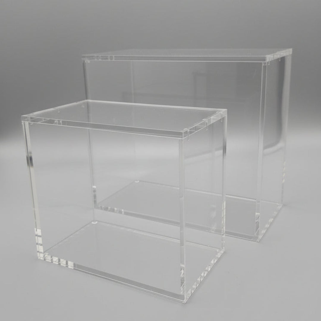 Two clear acrylic display stands on a black background