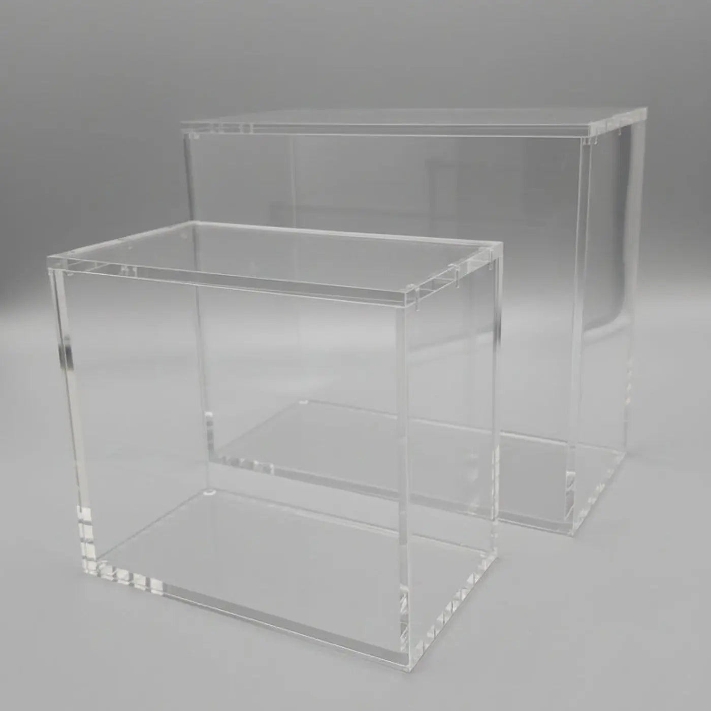 Two clear acrylic display stands on a black background