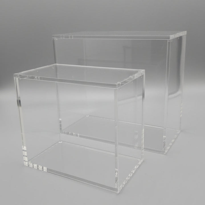 Two clear acrylic display stands on a black background
