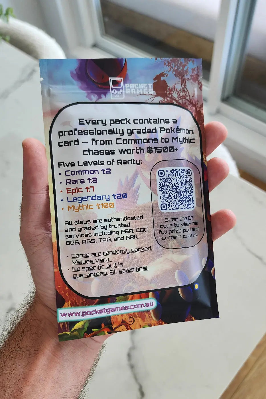 Hand holding a colorful trading card pack with text and a QR code.